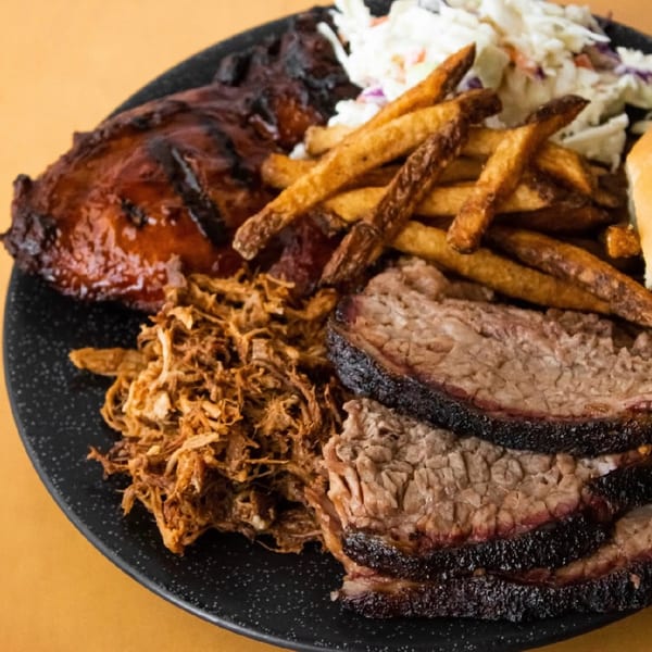 Combo platter with brisket, pulled pork, BBQ chicken, fries, and coleslaw